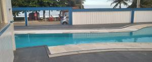 a swimming pool in front of a building with a parking lot at Cantinho dos sonhos in Piúma