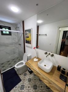 uma casa de banho com um WC, um lavatório e um chuveiro em Pousada Motta em Miguel Pereira