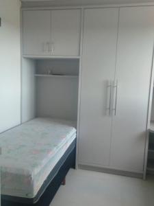 um quarto com uma cama e um armário branco em Cobertura Duplex Itapoá em Itapoá