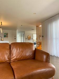 un divano in pelle marrone in soggiorno di 'Shore Thing' - Akaroa a St Helens
