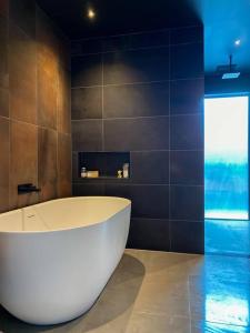 een badkamer met een bad en een raam bij 'Shore Thing' - Akaroa in St Helens