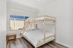a bedroom with a bunk bed and a window at Light & Bright Pet Friendly Beachside Haven in Old Dawesville in Dawesville