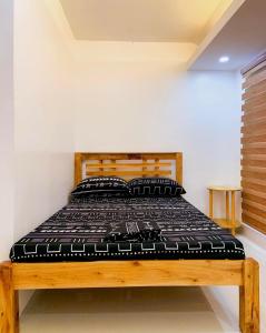 a bed with a wooden frame in a room at 2 Bedroom Townhouse- Near Clark Airport in Angeles