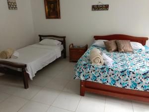 - une chambre avec 2 lits et une table de nuit dans l'établissement Finca Maratón Alto, à Calarcá