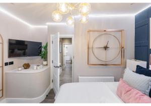 a bedroom with a bed and a clock on the wall at Modern London 3-Bedroom Flat in London