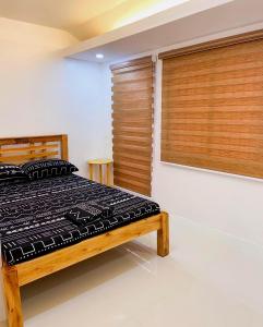 a bedroom with a bed and wooden blinds at 2 Bedroom Townhouse- Near Clark Airport in Angeles