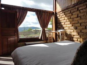 1 dormitorio con cama y ventana grande en Cabaña Isla Dorada en Guatavita