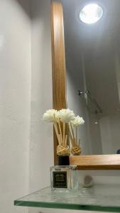 a vase with flowers in front of a mirror at 2 Bedroom Townhouse- Near Clark Airport in Angeles