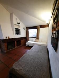 a living room with a bed and a fireplace at Terrazas del Venado in La Cumbre