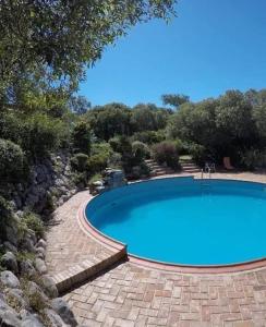 una piscina en un paisaje con una pasarela de piedra alrededor en Terrazas del Venado en La Cumbre