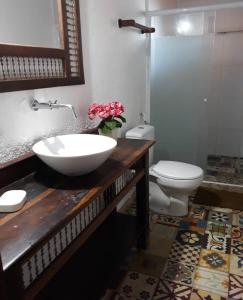 uma casa de banho com um lavatório branco e um WC. em Sossego entre as montanhas de Itaipava em Petrópolis