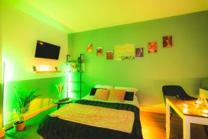 zieloną sypialnię z łóżkiem i biurkiem w obiekcie LE REFUGE - NETFLIX I WIFI HAUT DEBIT I PARKING - Confort & Cosy w mieście Valenciennes