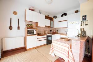 パレオ・ティフリキにあるLoukas Houseの白いキャビネットとテーブル付きのキッチンが備わります。