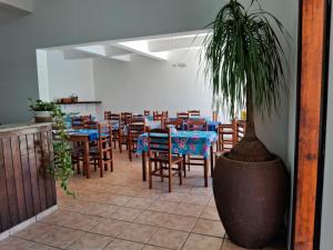 restauracja ze stołami i krzesłami oraz doniczką w obiekcie Pousada Sol da Lagoinha w mieście Ubatuba