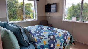 a bedroom with a bed and two windows at Happy Home in Taupo