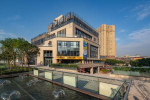 重慶市にあるWuyu Hotel - Chongqing Yuanyang Light Rail Stationの池のある大きな建物