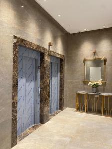 a bathroom with two blue doors and a mirror at Résidence kadicia oran in Oran