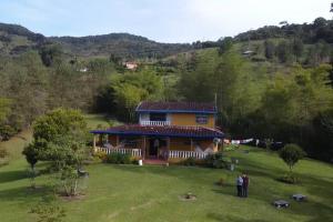 a group of people standing in front of a house at La Escondida, con acceso al lago in Guatapé