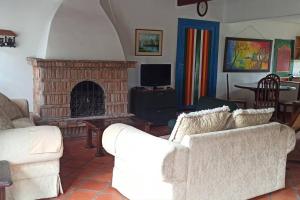 a living room with two white couches and a fireplace at La Escondida, con acceso al lago in Guatapé