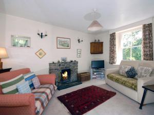 a living room with a couch and a fireplace at Carreg Yr Eos - Cottage in Fishguard