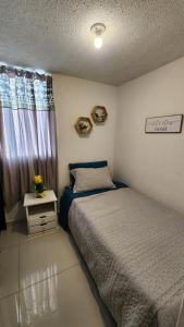 una piccola camera con letto e finestra di Apartamento central a Medellín