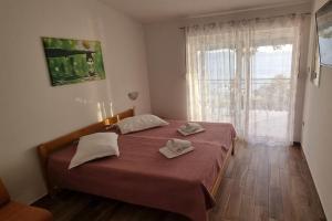 1 dormitorio con 1 cama con 2 toallas en Apartments with a parking space Zivogosce - Porat, Makarska - 16289, en Živogošće