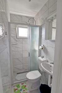 e bagno con doccia, servizi igienici e lavandino. di Apartments with a parking space Zivogosce - Porat, Makarska - 16289 a Živogošće (Svogoschia)