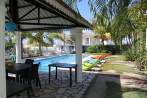 a patio with a table and a swimming pool at Marisa Residences in La Gaulette