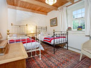 um quarto com 2 camas num quarto com uma janela em Hallowarren Barn em Saint Anthony