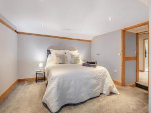 a bedroom with a large white bed with a window at Rod Line Cottage in Croft