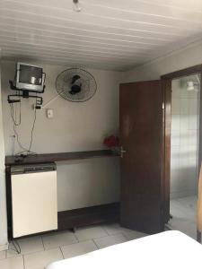 eine Küche mit einer Tür und einem TV an der Wand in der Unterkunft Pousada Maringá in Guaratuba
