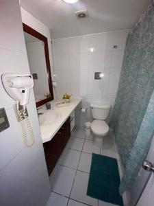 a bathroom with a toilet and a sink and a phone at Alcantara'S Merced 562 in Santiago