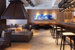富良野Nozo Hotel的有酒吧和桌椅的餐厅