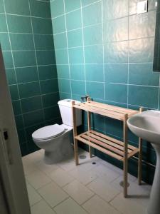 a bathroom with a toilet and a sink at Central Atlantic Beach Guesthouse in Costa da Caparica