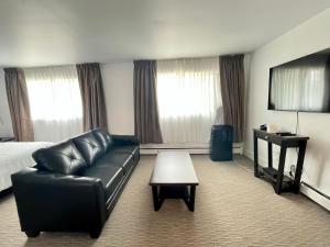 a hotel room with a couch and a bed and a table at Anavada Inn & Suites - Prince George in Prince George