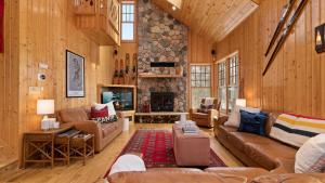 ein Wohnzimmer mit Möbeln und einem Steinkamin in der Unterkunft Shady Pines On Kimble Lake in Pequot Lakes