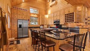 eine Küche mit Holzschränken und eine Insel mit Barhockern in der Unterkunft Shady Pines On Kimble Lake in Pequot Lakes