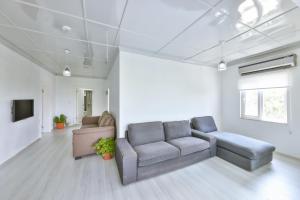 a living room with a couch and a tv at AGACH Apart 1 & 2 in Milas