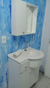 W łazience znajduje się biała umywalka i lustro. w obiekcie Casa sambaqui w mieście Florianópolis