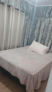 łóżko z białą poduszką na górze w obiekcie Casa sambaqui w mieście Florianópolis