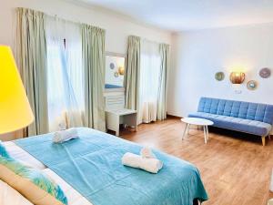 1 dormitorio con 1 cama azul y 1 sofá azul en Hotel Miramar, en Puerto de Sóller