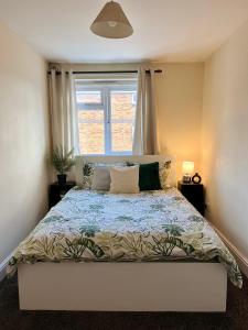 1 dormitorio con 1 cama grande y ventana en Entire 3 bedroom end of terrace house!, en Thamesmead