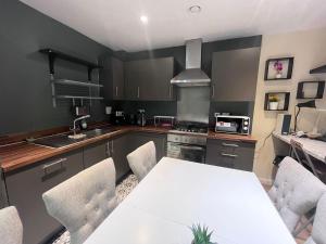 a kitchen with a white table and chairs in it at Rooms near Canary wharf in London