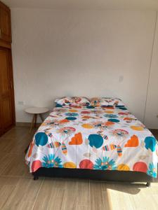 Una cama con un edredón colorido en un dormitorio en Apartahotel Villa Carolina 4, en Jericó