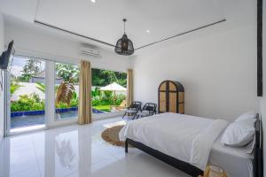- une chambre avec un lit et une grande fenêtre dans l'établissement Villa Primarosa - Charming 2BR Villa in Pererenan, à Munggu