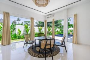 a dining room with a table and chairs at Villa Primarosa - Charming 2BR Villa in Pererenan in Munggu