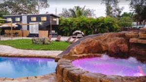 a swimming pool with a waterfall in a rock at 108 Tiny House Bradenton in Bradenton