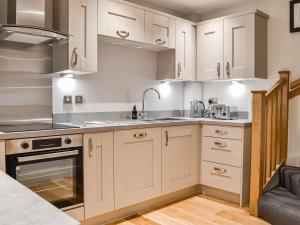 een keuken met witte kasten en een wastafel bij Pride Of Erin - Uk45929 in Linlithgow