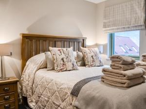 een slaapkamer met een bed met handdoeken erop bij Pride Of Erin - Uk45929 in Linlithgow