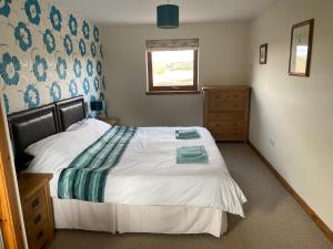 a bedroom with a large bed and a window at The Barn in Lairg